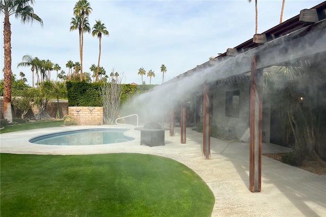 view of swimming pool featuring a lawn, a fire pit, and a patio