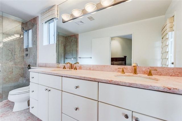 bathroom featuring toilet, a shower with shower door, and vanity