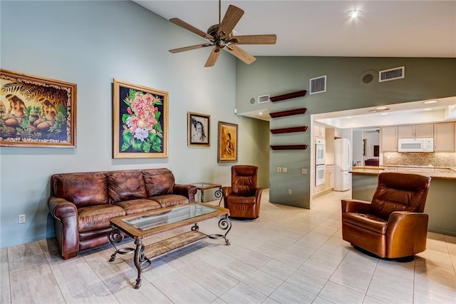 living room featuring ceiling fan, light tile patterned flooring, and high vaulted ceiling