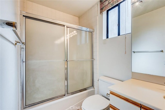 full bathroom with toilet, enclosed tub / shower combo, and vanity