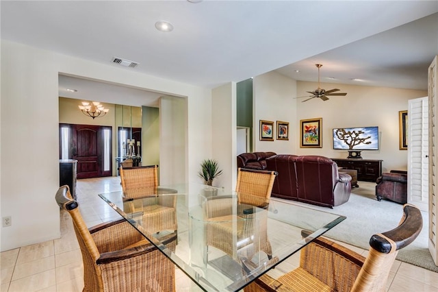 tiled dining area with vaulted ceiling and ceiling fan with notable chandelier