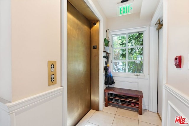 doorway with light tile patterned floors and elevator