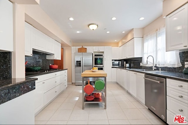 kitchen with extractor fan, sink, light tile patterned flooring, white cabinetry, and appliances with stainless steel finishes