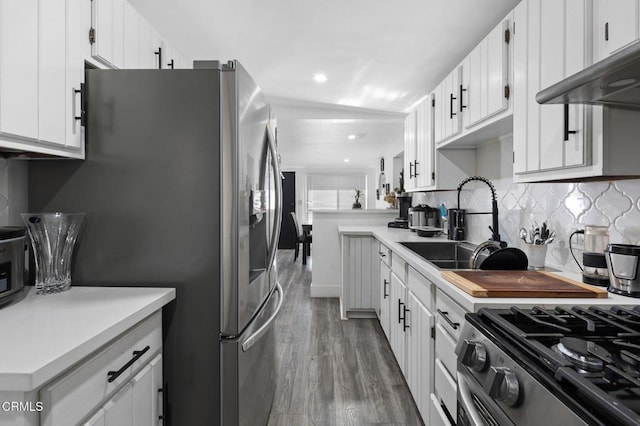 kitchen with lofted ceiling, dark hardwood / wood-style floors, sink, white cabinetry, and appliances with stainless steel finishes