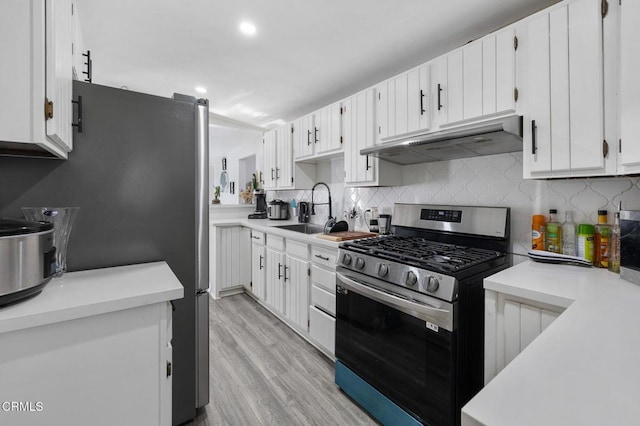 kitchen featuring white cabinetry, light hardwood / wood-style floors, appliances with stainless steel finishes, decorative backsplash, and sink