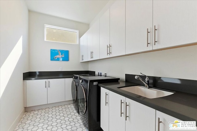 laundry area featuring cabinets, washer and clothes dryer, and sink