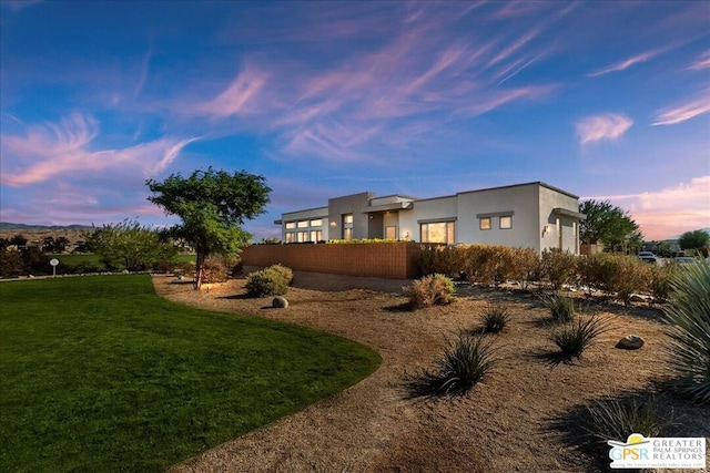 property exterior at dusk with a yard