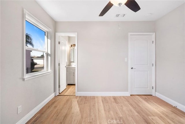 unfurnished bedroom featuring light wood-type flooring, ceiling fan, and connected bathroom