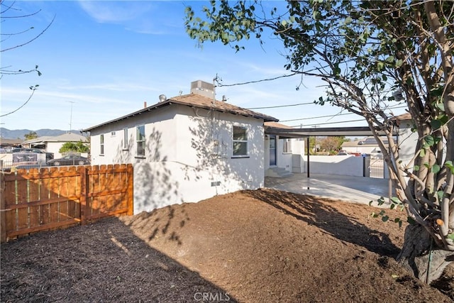 back of house featuring a mountain view and a patio