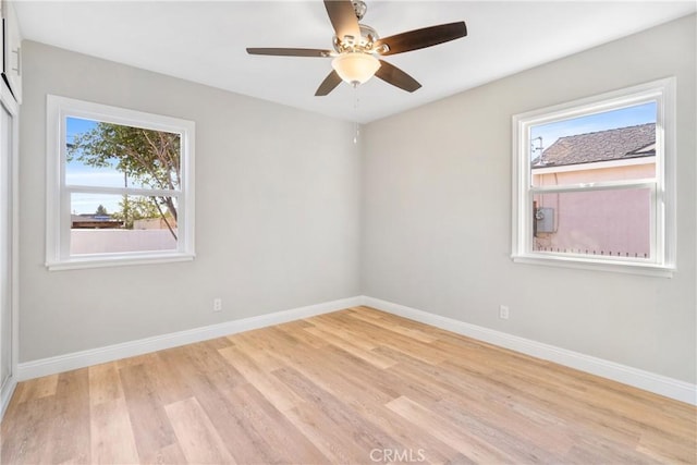 unfurnished room with ceiling fan, light wood-type flooring, and a wealth of natural light