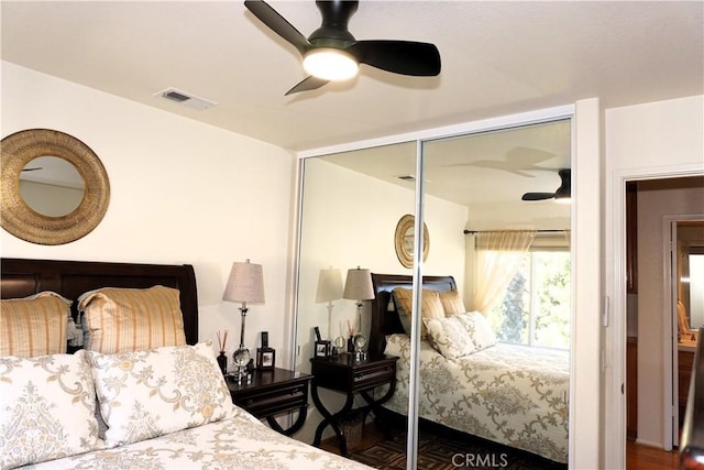 bedroom with dark wood-type flooring, a closet, and ceiling fan