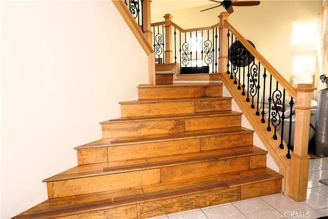 stairs featuring tile patterned floors and ceiling fan