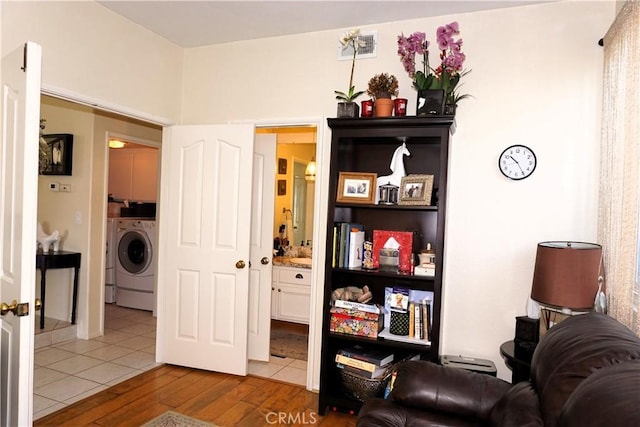 33 Corte Palazzo, Lake Elsinore, CA 92532 - sitting room featuring washer / clothes dryer and wood finished floors