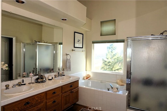 bathroom featuring vanity and independent shower and bath