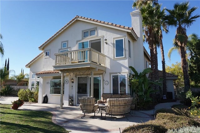 back of property featuring outdoor lounge area, a patio, and a balcony