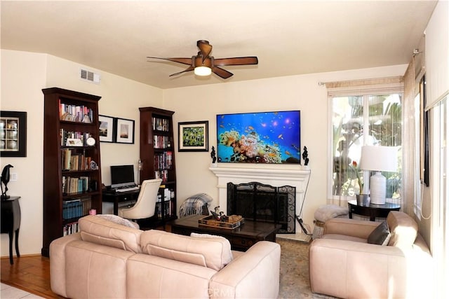 33 Corte Palazzo, Lake Elsinore, CA 92532 - living area with a ceiling fan and a fireplace with raised hearth
