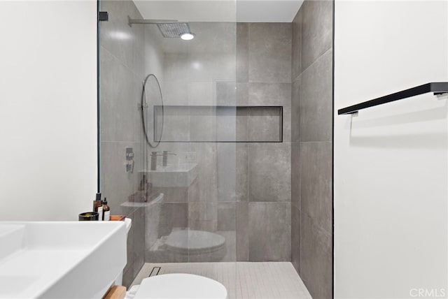 bathroom featuring toilet and tiled shower