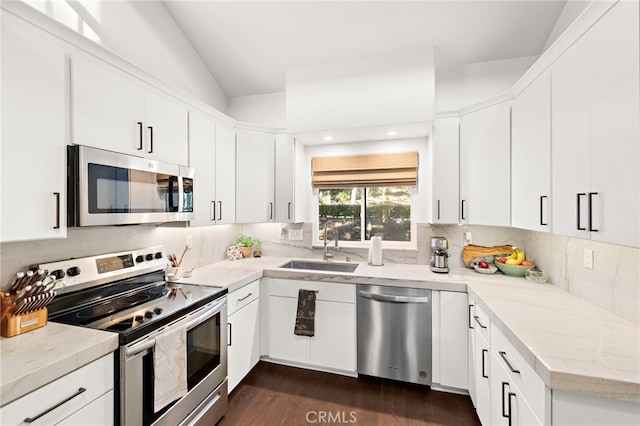 kitchen featuring white cabinetry, appliances with stainless steel finishes, and lofted ceiling