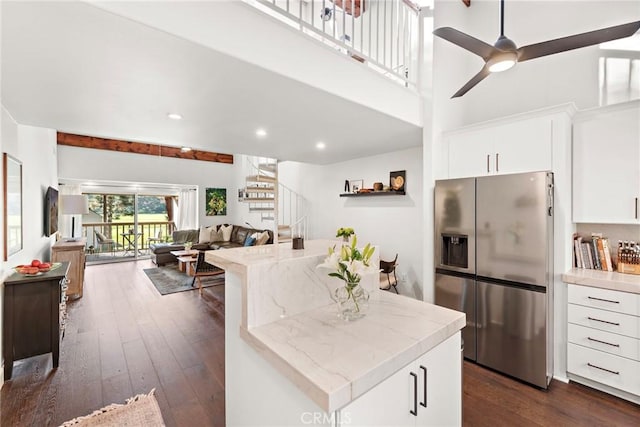 kitchen with ceiling fan, dark wood-type flooring, white cabinetry, and stainless steel fridge