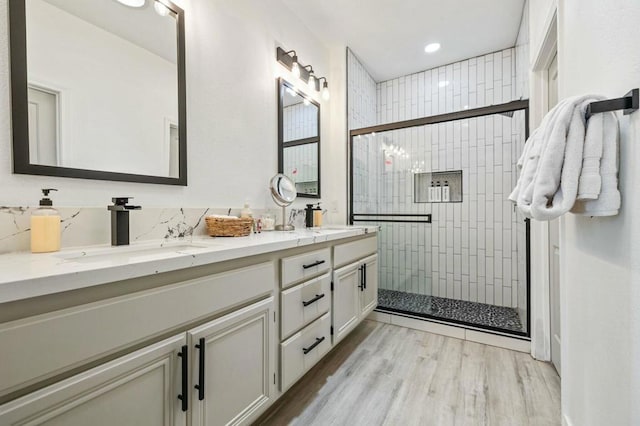 bathroom with vanity, backsplash, hardwood / wood-style flooring, and an enclosed shower