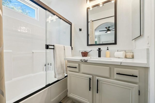 bathroom with combined bath / shower with glass door, vanity, and ceiling fan