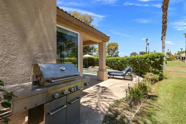 view of patio with area for grilling and a pool