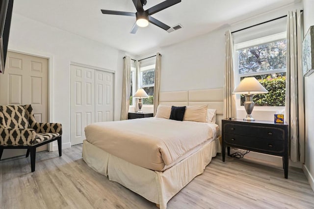 bedroom with ceiling fan, light hardwood / wood-style flooring, and a closet