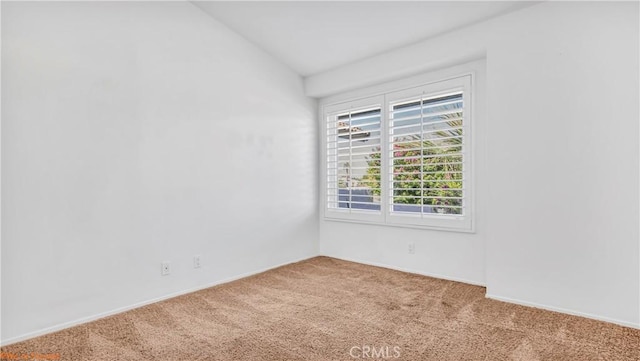 carpeted spare room with lofted ceiling