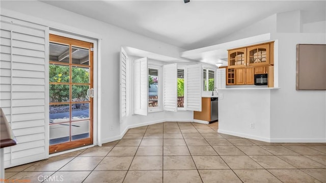 unfurnished dining area featuring light tile patterned floors and vaulted ceiling