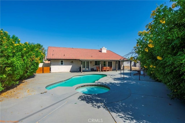 view of pool featuring french doors, a patio, and an in ground hot tub