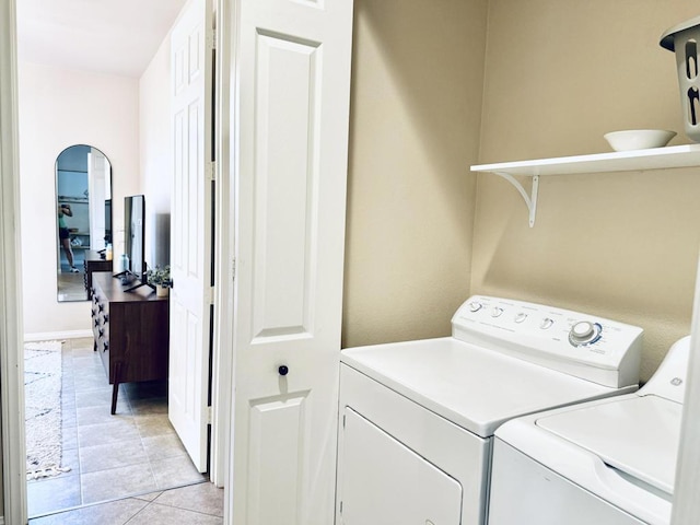 laundry area with light tile patterned floors and washing machine and dryer