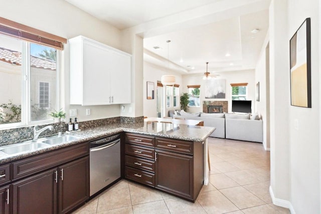 kitchen with stainless steel dishwasher, kitchen peninsula, sink, white cabinets, and dark brown cabinets