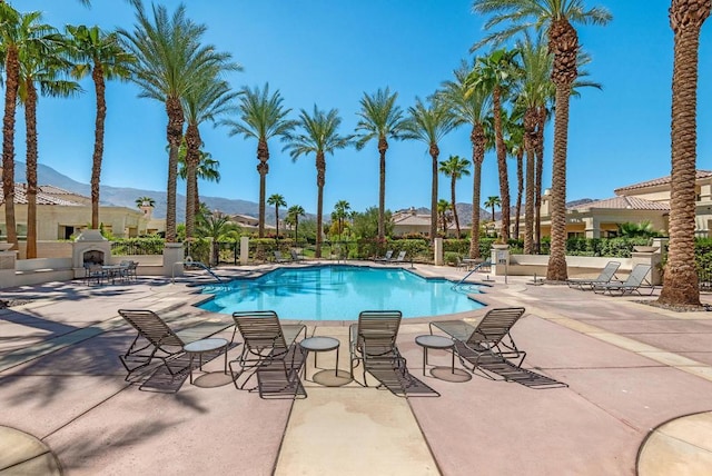 view of swimming pool featuring a mountain view and a patio