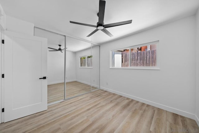 unfurnished bedroom with light wood-type flooring, ceiling fan, and a closet