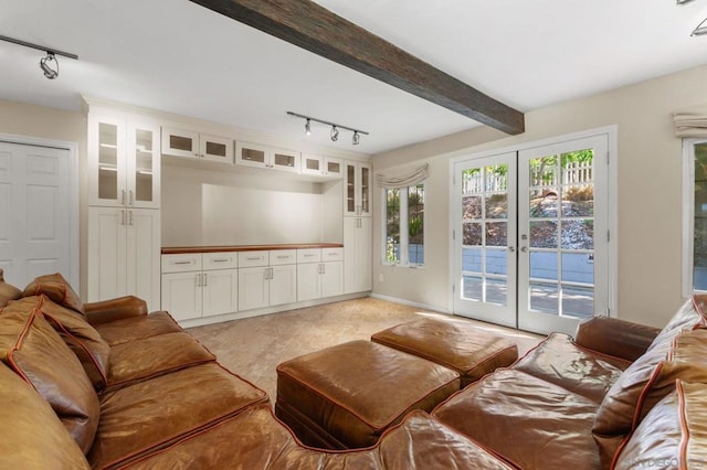 living room with track lighting, beam ceiling, and french doors