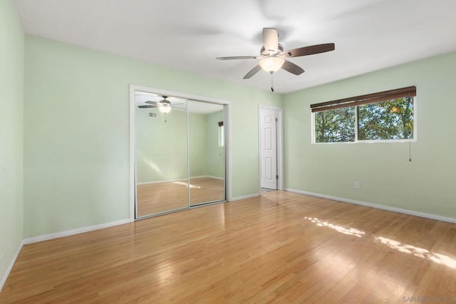 unfurnished bedroom with ceiling fan, hardwood / wood-style flooring, and a closet