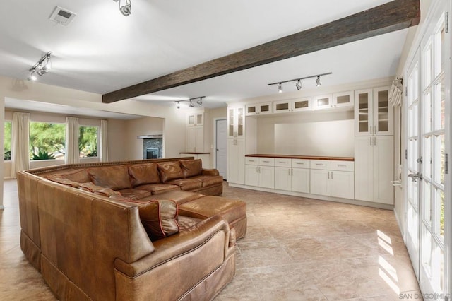 living room featuring beam ceiling and french doors