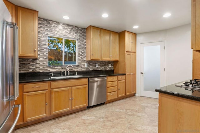 kitchen featuring tasteful backsplash, appliances with stainless steel finishes, sink, and dark stone countertops