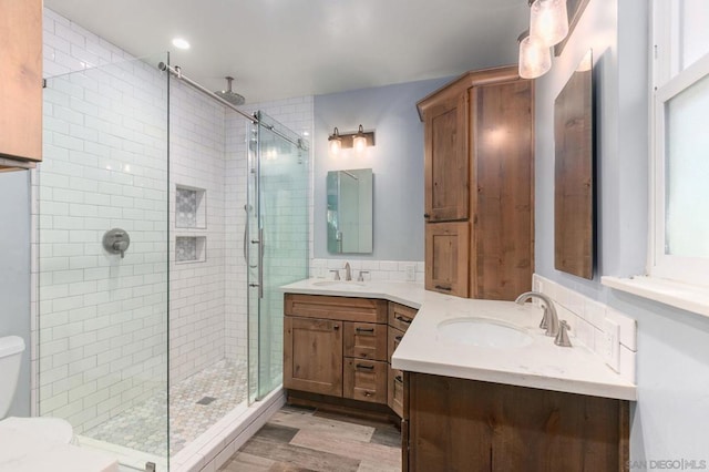 bathroom featuring a shower with shower door, vanity, and hardwood / wood-style floors