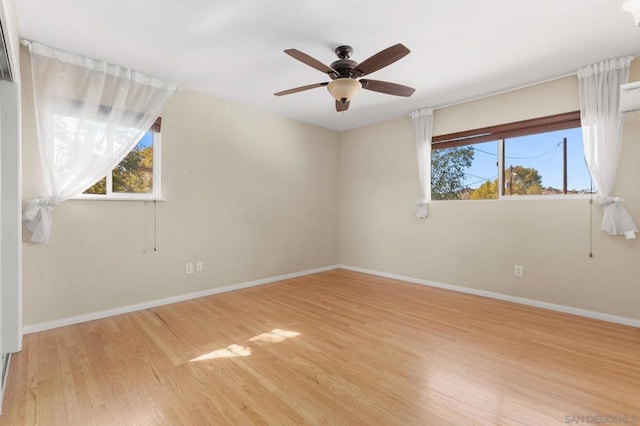 empty room with ceiling fan and light hardwood / wood-style floors