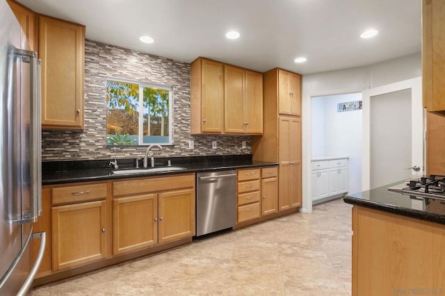 kitchen with sink, backsplash, stainless steel appliances, and dark stone counters