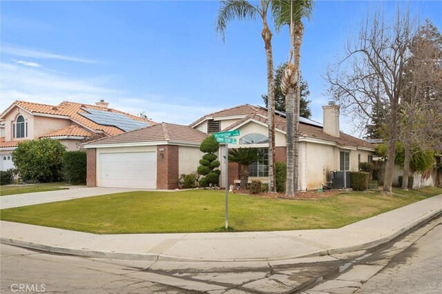 view of front of home with a front yard, a garage, and central AC