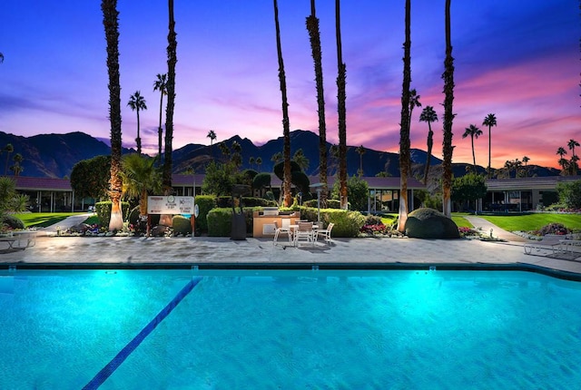 pool at dusk with a mountain view and a patio