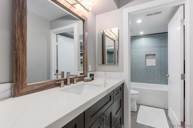 full bathroom with toilet, vanity, and tiled shower / bath combo