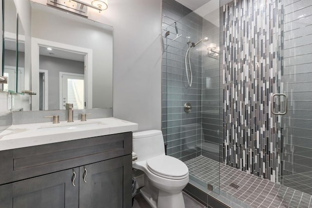 bathroom featuring toilet, walk in shower, and vanity