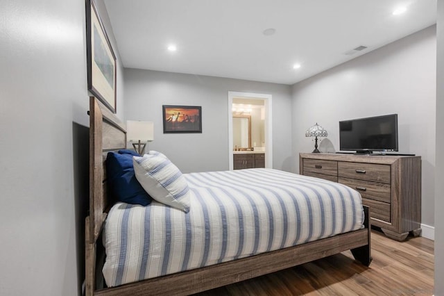 bedroom featuring light hardwood / wood-style floors and connected bathroom