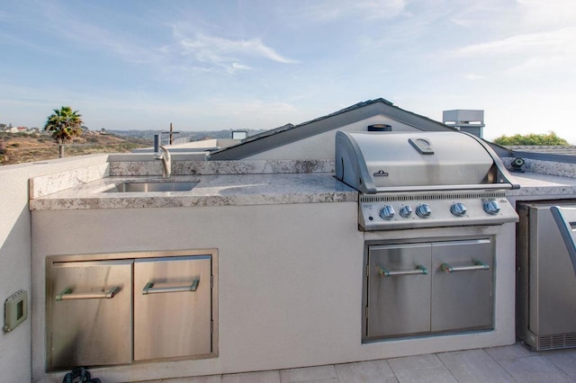 view of patio / terrace with a grill, an outdoor kitchen, and sink