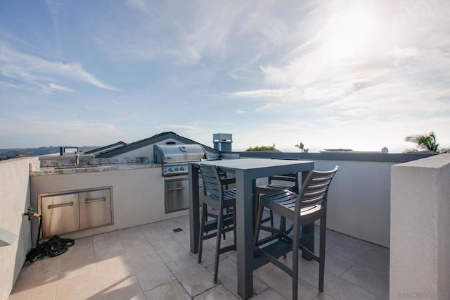 view of patio with exterior kitchen, sink, and a grill