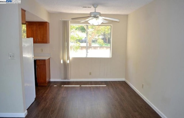 unfurnished dining area with ceiling fan and dark hardwood / wood-style floors