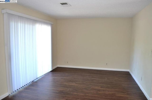 spare room with dark hardwood / wood-style flooring